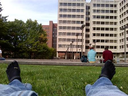 Derek finds a nice spot on campus to relax after class on a first floor grassy terrace.