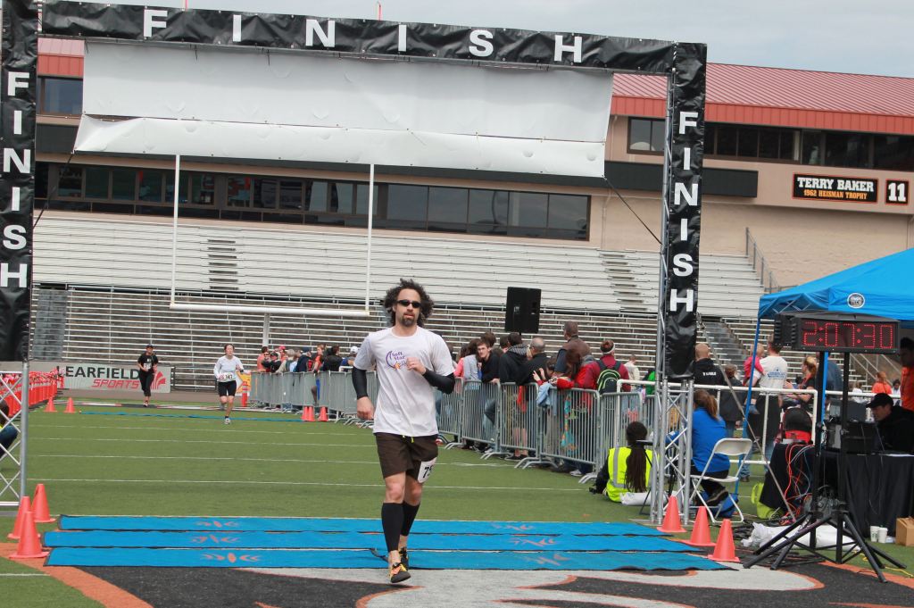 Jay crosses the finish line in the Corvallis Half Marathon - on the Oregon State football field in 2:07 sporting some hornet-colored Dash Soft Start RunAmocs.