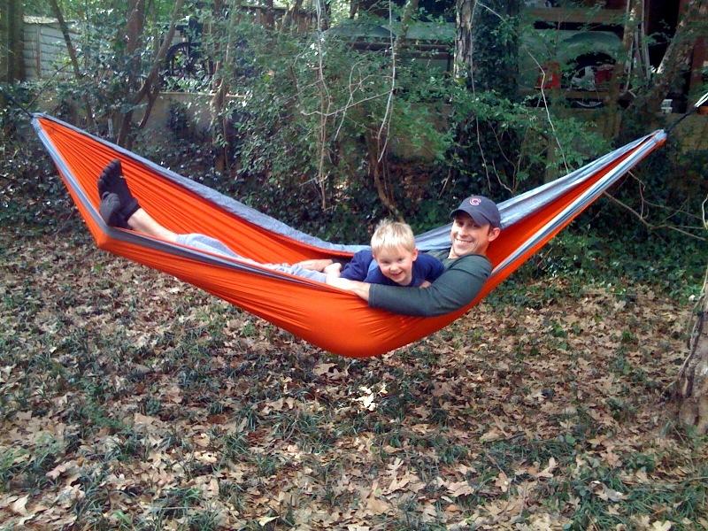 Josh kicks back and relaxes with his son on his hammock in his black KSO Vibram Five Fingers.